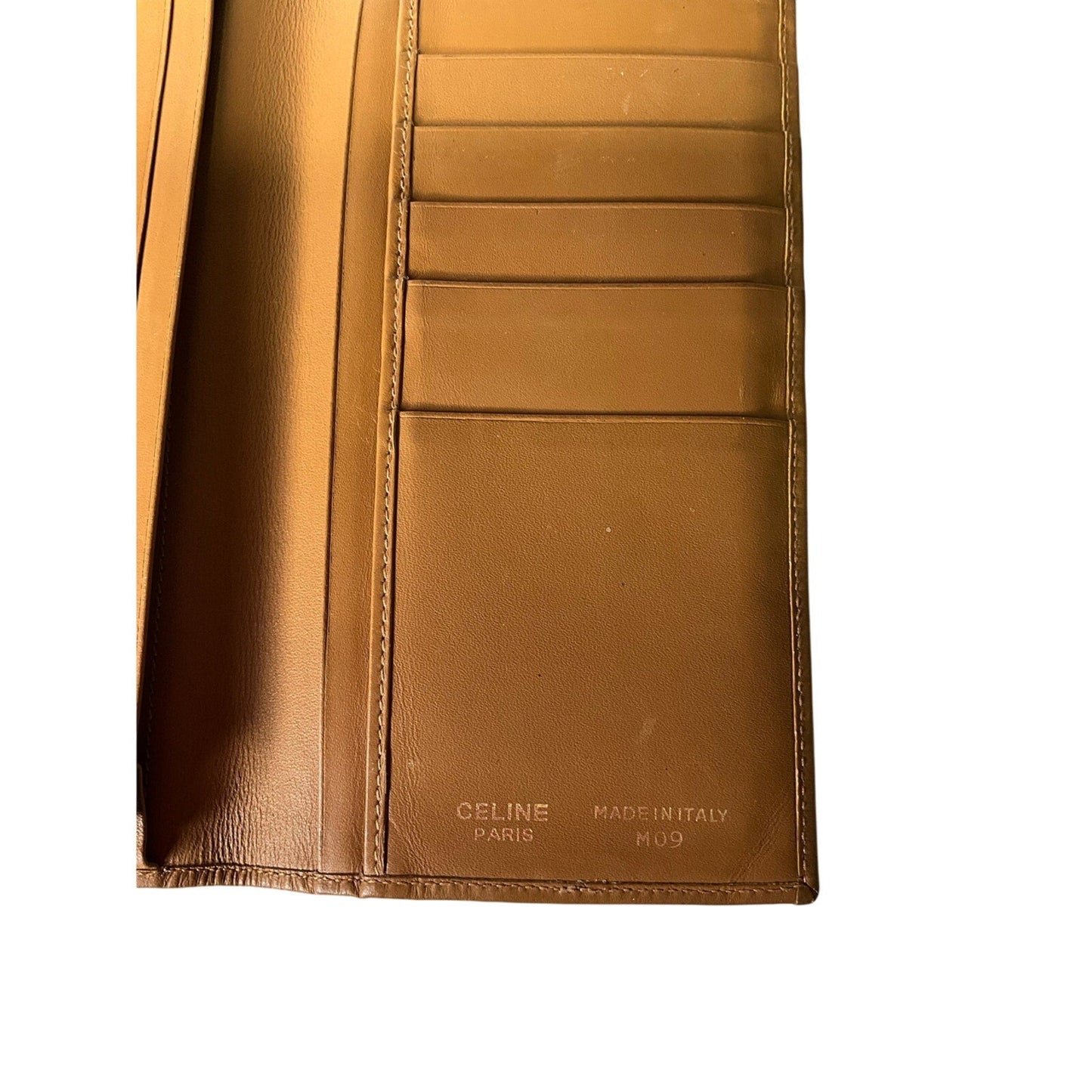 Brown leather wallet with visible Celine branding on a white background