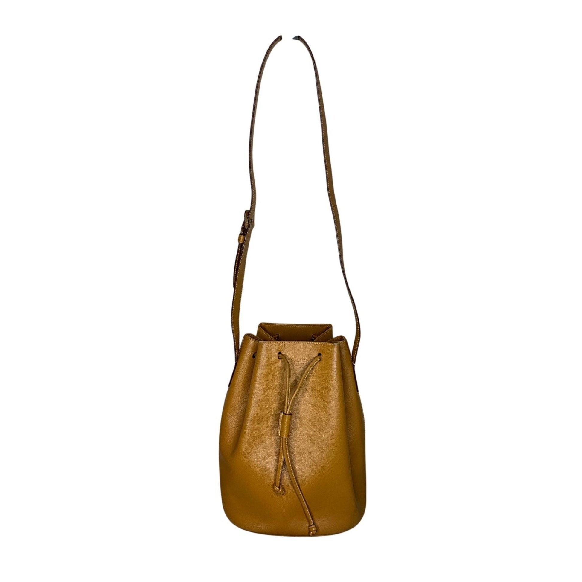 Brown leather bucket bag with a strap on a white background