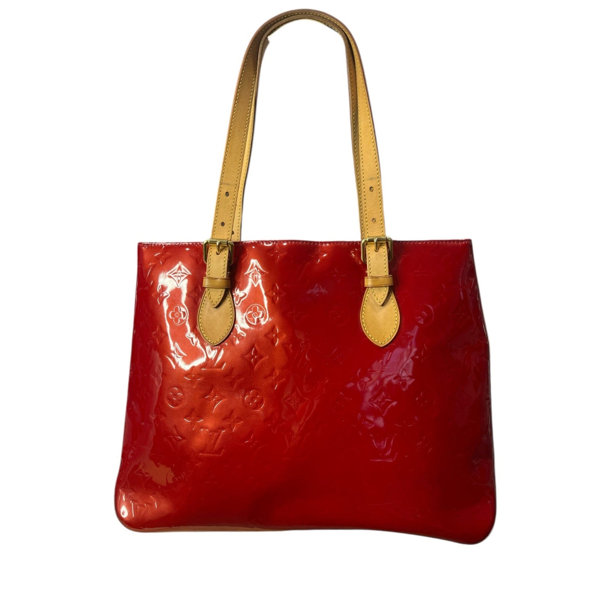 Red patent leather handbag with yellow handles on a white background