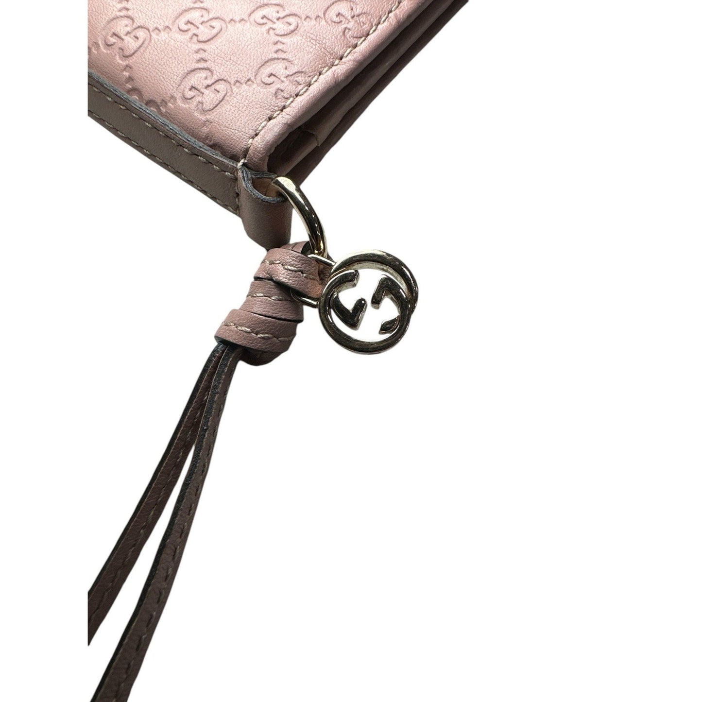 Close-up of a pink textured pouch with a brown strap and logo on a white background