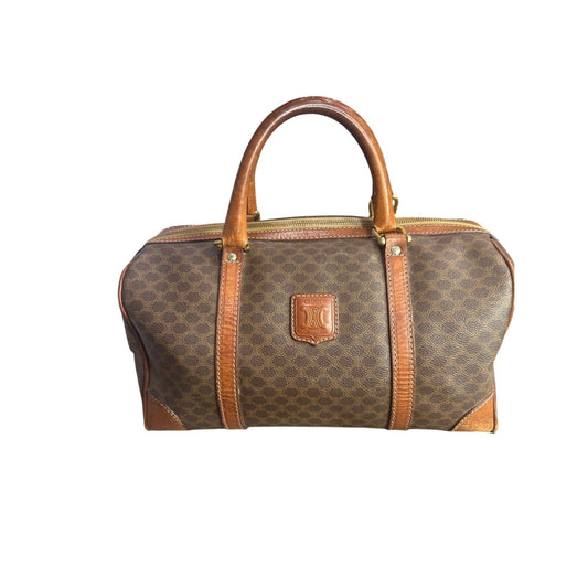 Brown patterned handbag with brown handle and trim on a white background
