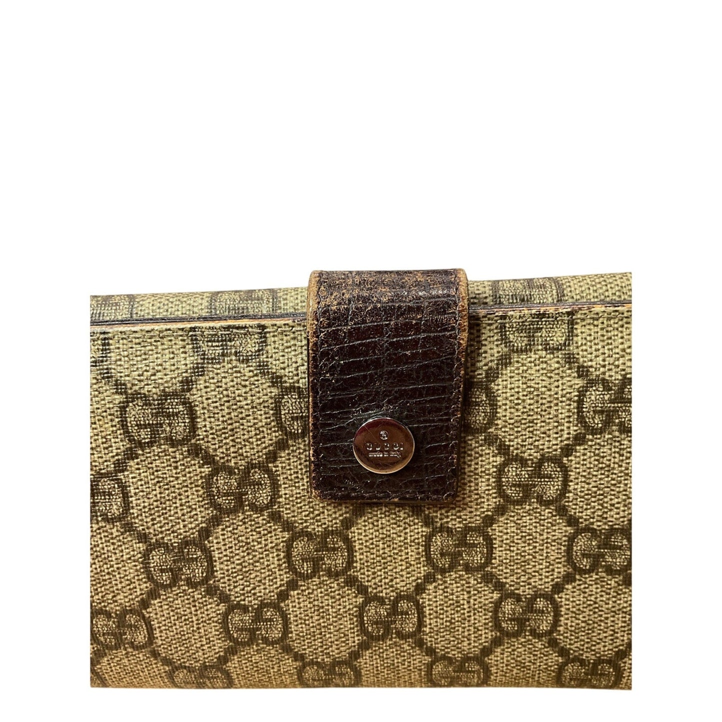 Designer handbag with patterned fabric and brown leather strap on a white background