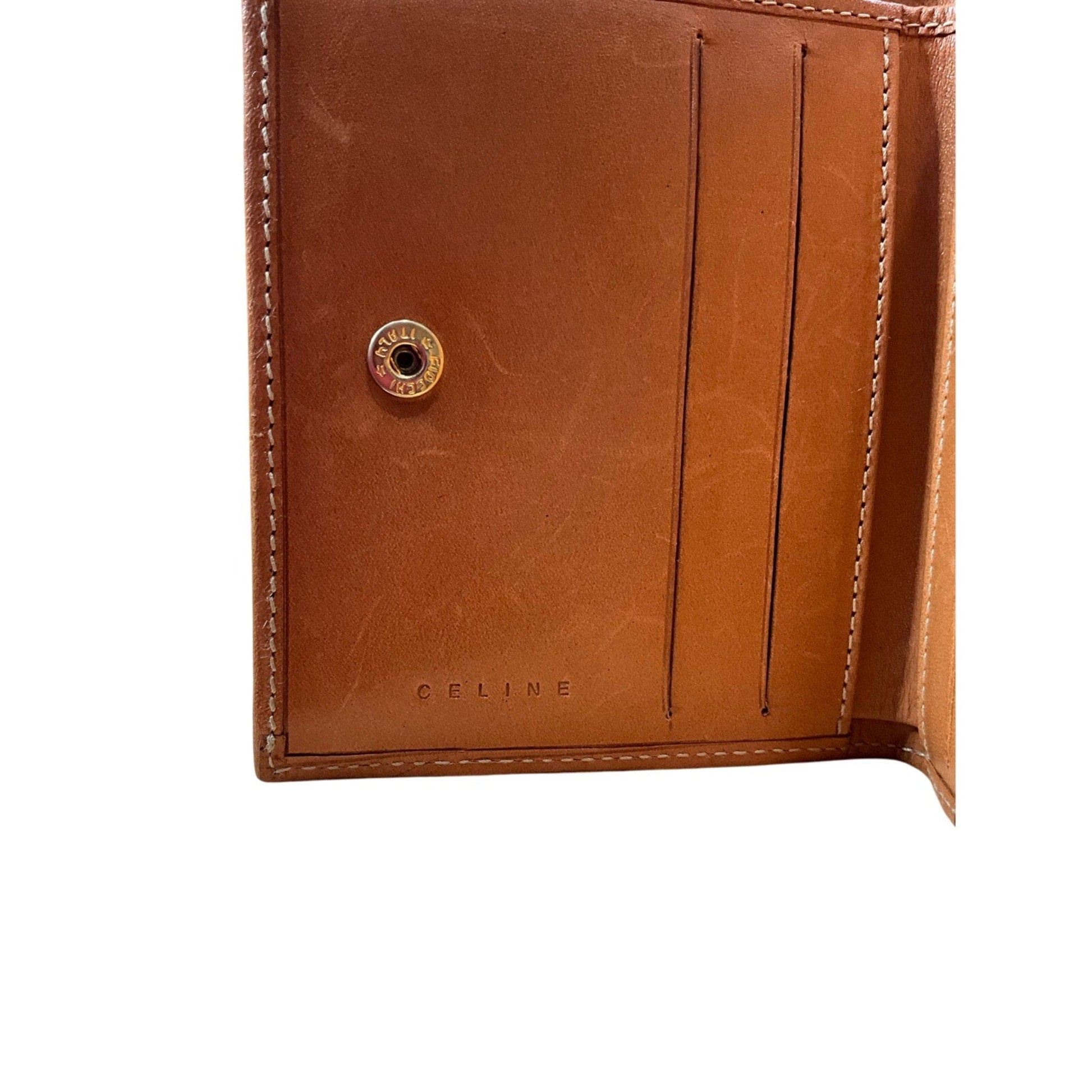 Brown leather wallet with gold button and 'CELINE' branding on a white background