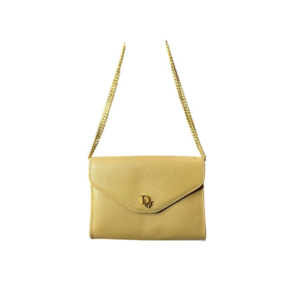 Yellow handbag with gold chain strap on a white background