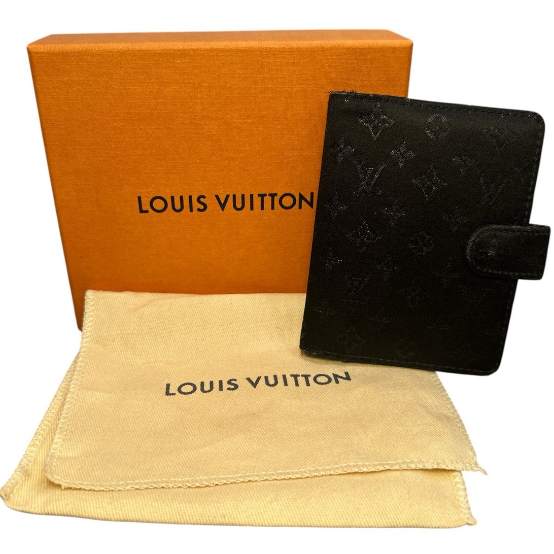 Louis Vuitton black wallet with orange box and beige pouch on a white background