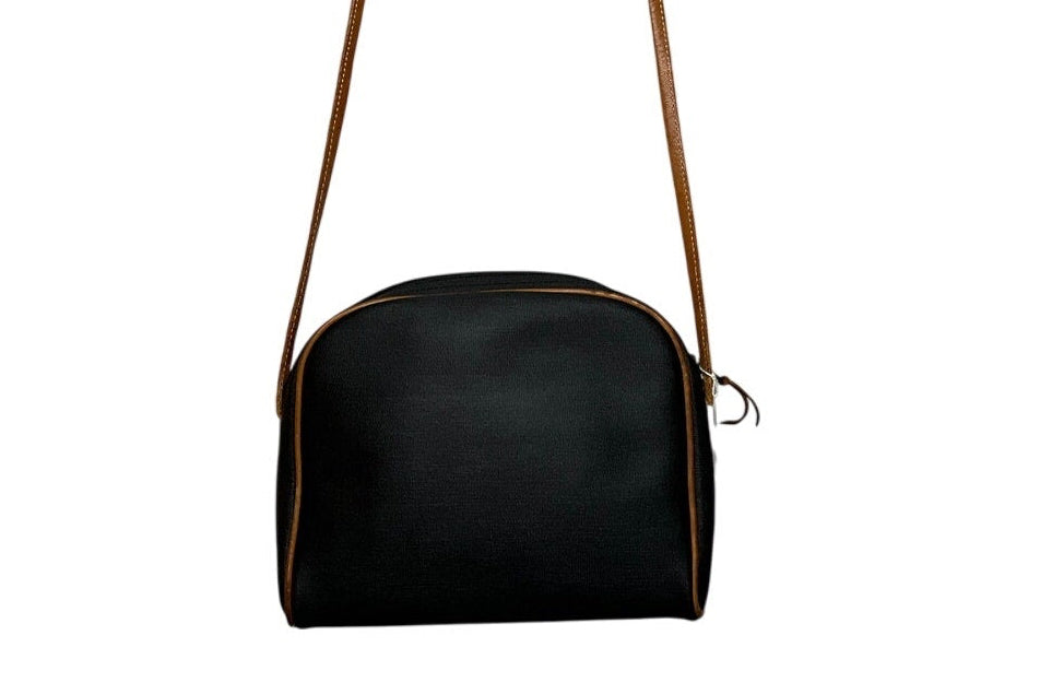 Black handbag with a brown strap on a white background