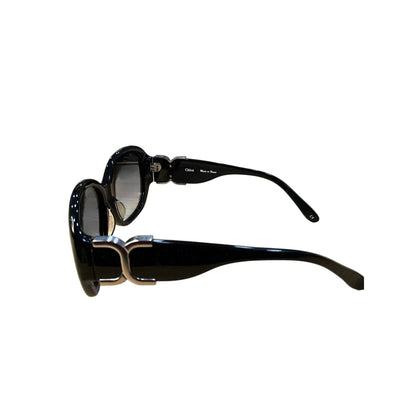 Black sunglasses with gold accents on a white background