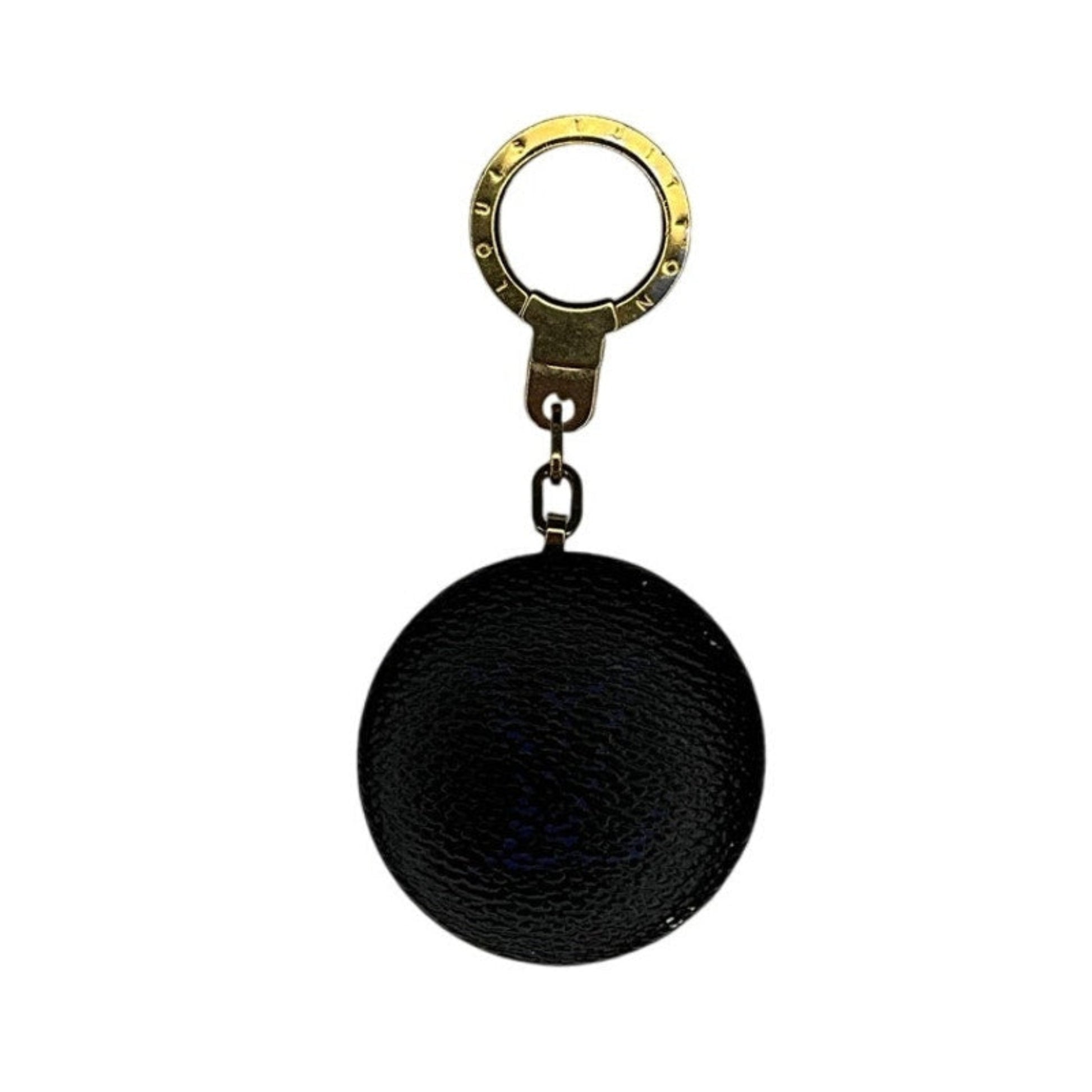 Black spherical keychain with a gold ring on a white background