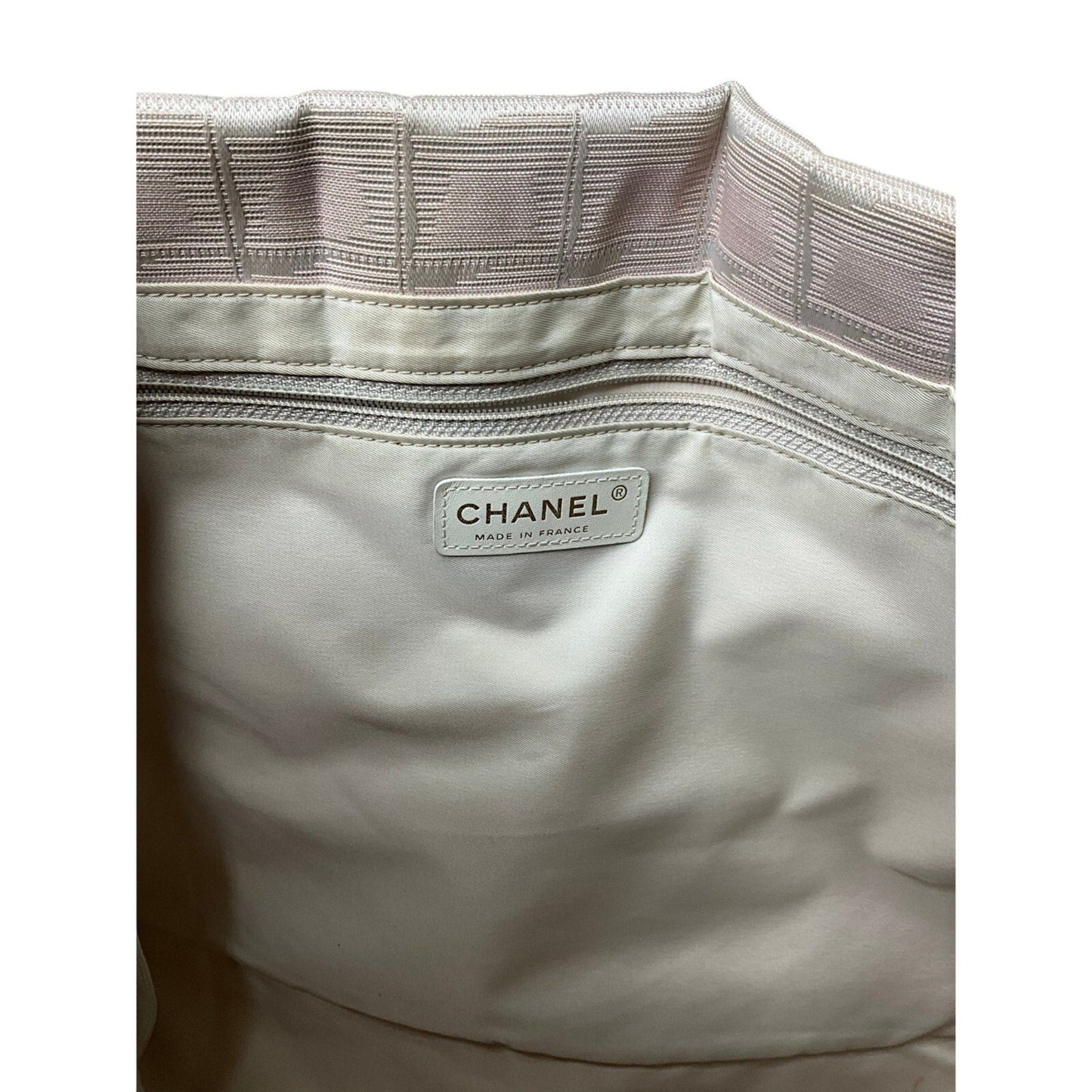 Close-up of a Chanel bag with a visible label on a white background
