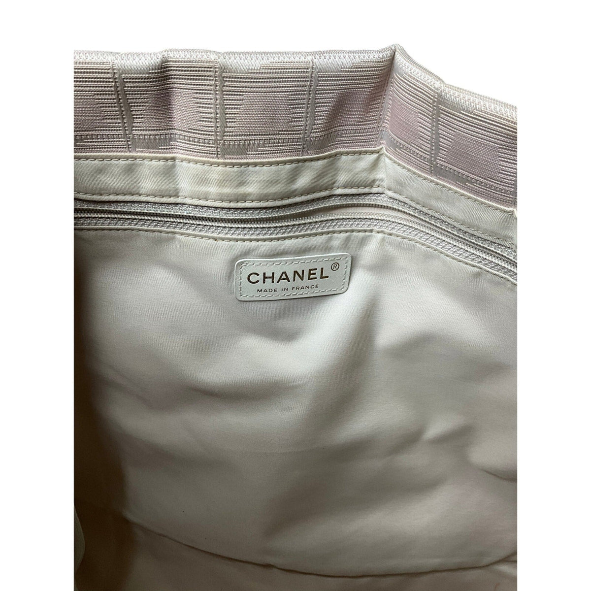 Close-up of a Chanel bag with a visible label on a white background