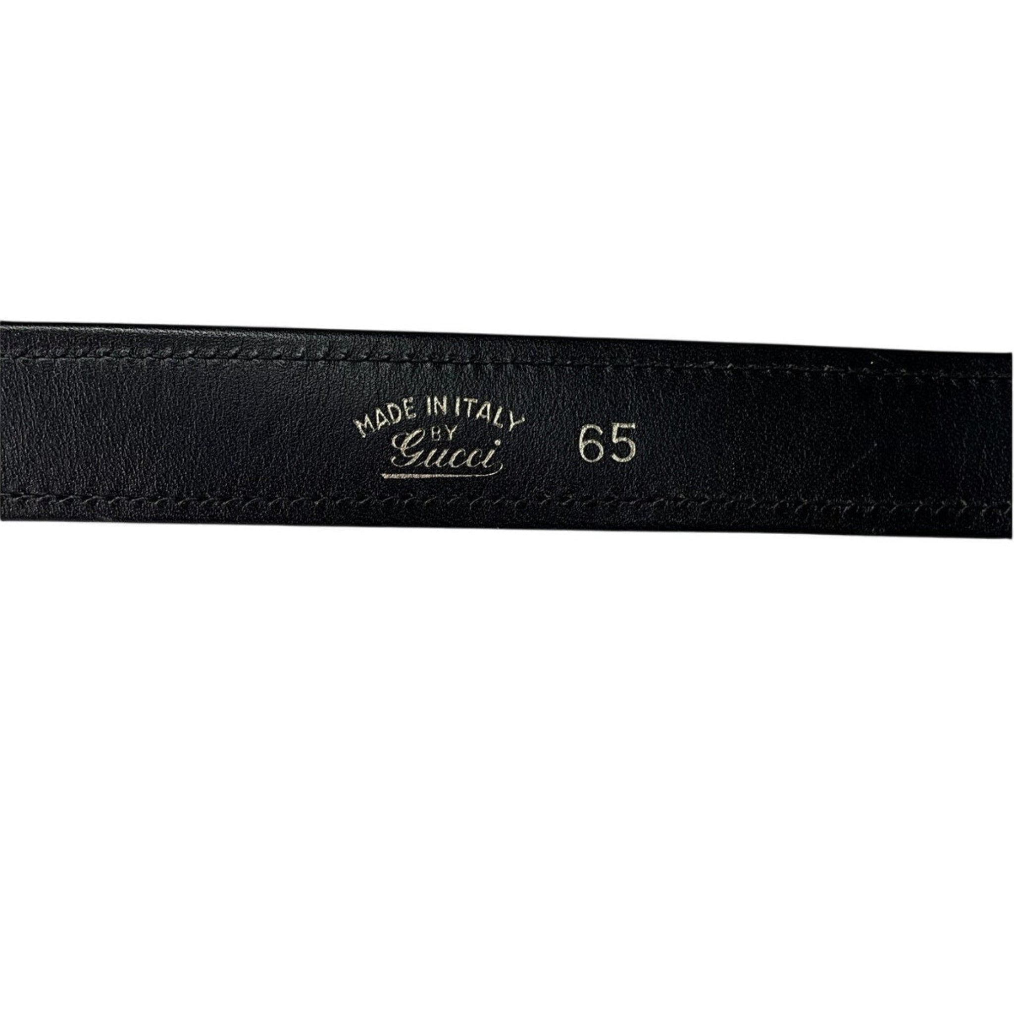 Black leather belt with 'Made in Italy by Gucci' engraving on a white background