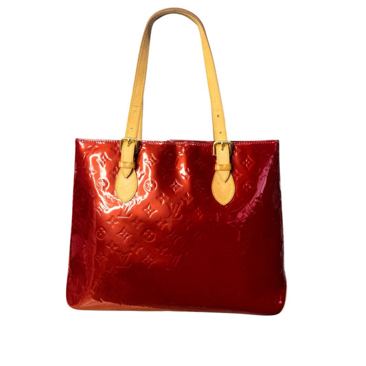 Red handbag with yellow handles on a white background