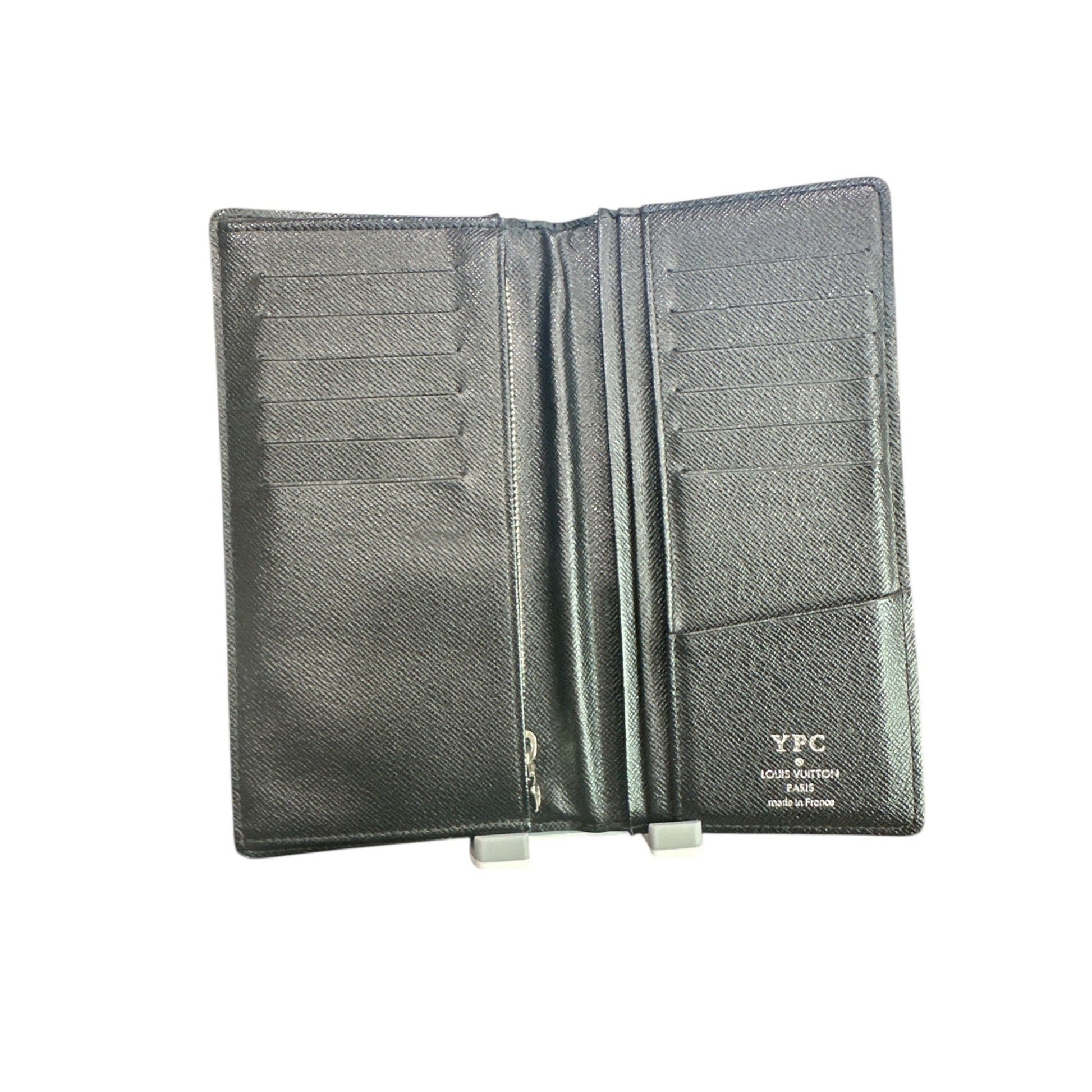 Black leather passport holder with visible brand name on a white background