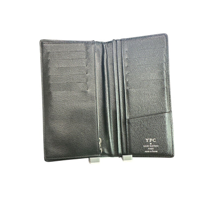 Black leather passport holder with visible brand name on a white background