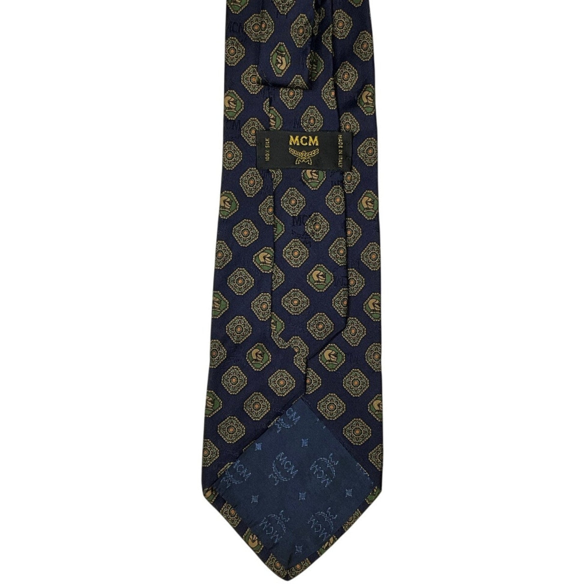 Navy blue tie with gold pattern and MCM logo on a white background