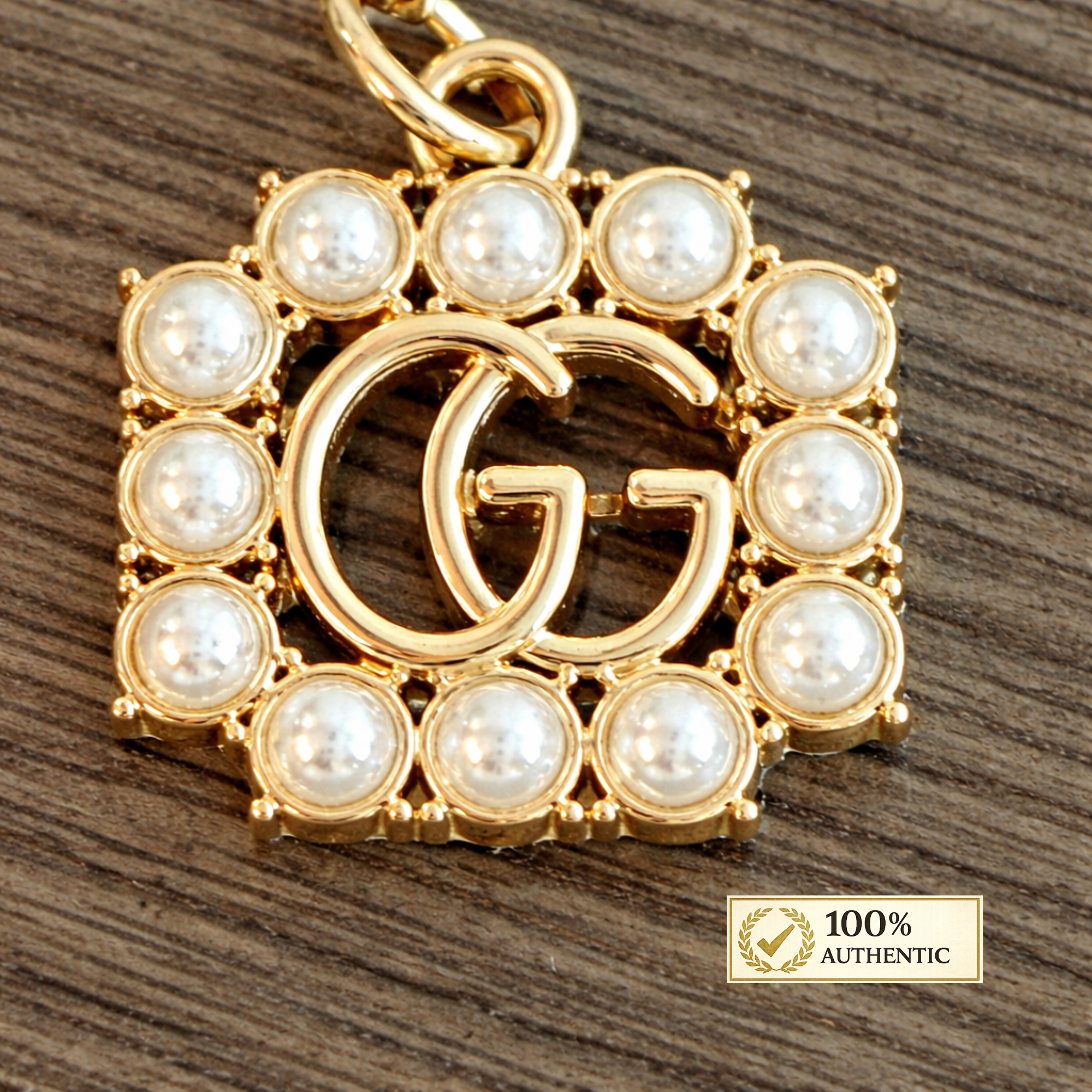 Tirador de cremallera/dije "GG" de Gucci, tono dorado, perlas de imitación, estampado Gucci