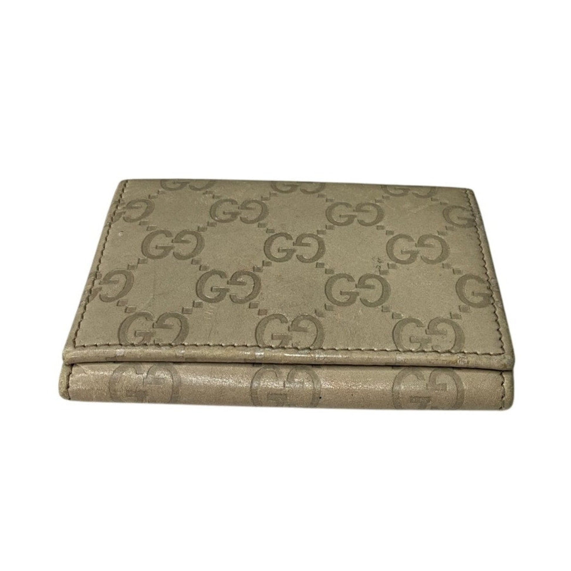Beige wallet with Gucci logo pattern on a white background