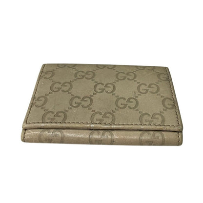 Beige wallet with Gucci logo pattern on a white background