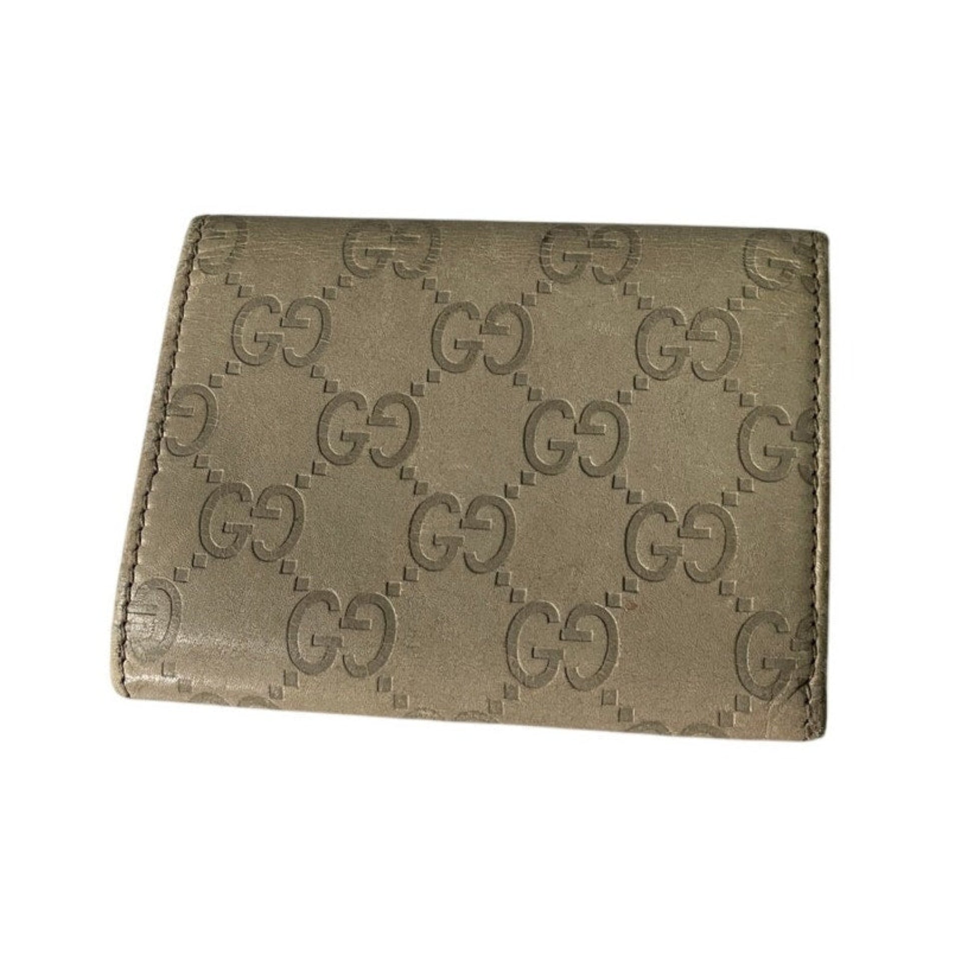 Beige wallet with Gucci logo pattern on a white background
