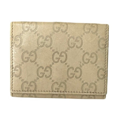 Beige wallet with Gucci logo pattern on a white background
